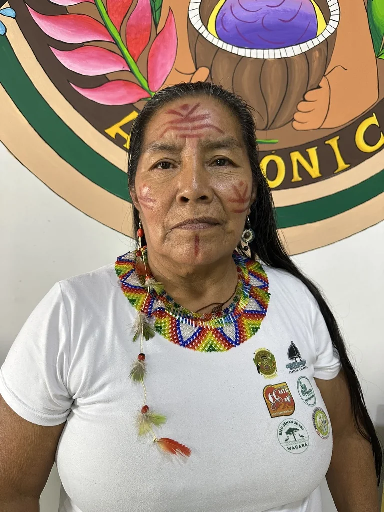 Indigenous woman ambassador with elaborate beaded necklace and traditional face paint at Dulce Amazónica, Guatapé