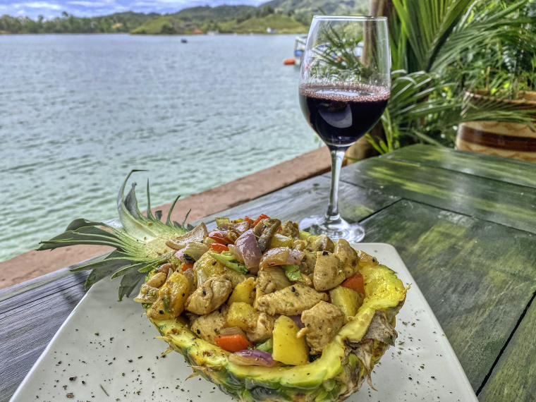 Chicken in pineapple bowl with red wine at Casa de Ciclistas, Guatapé reservoir in background