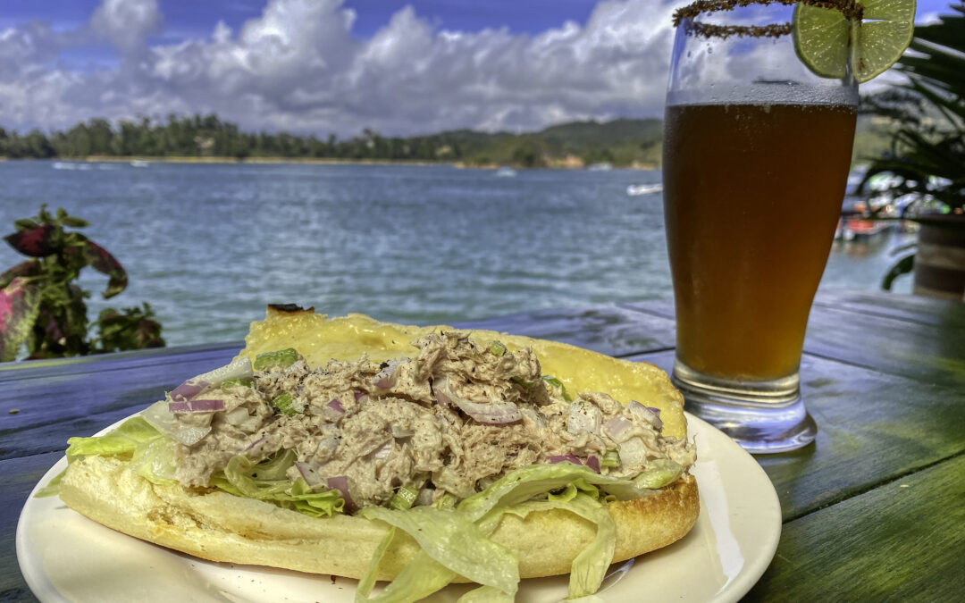 Open-faced sandwich and beer on the terrace at Casa de Ciclistas with the Guatapé reservoir behind